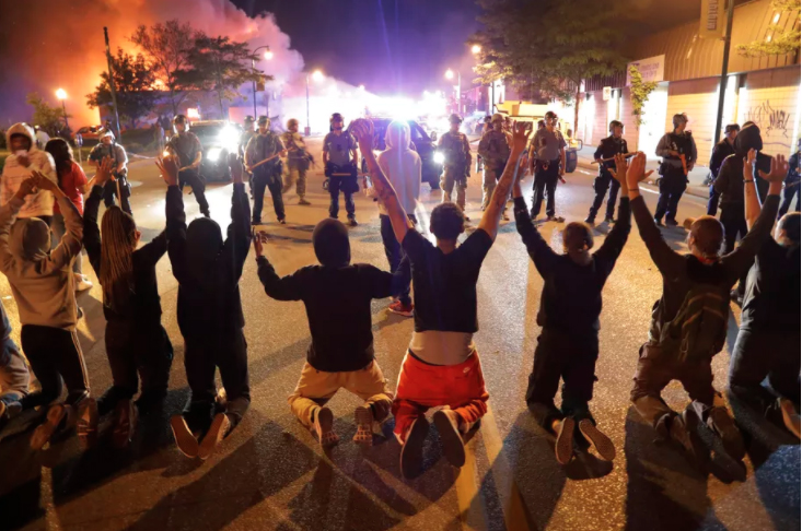 Protestors kneel before police